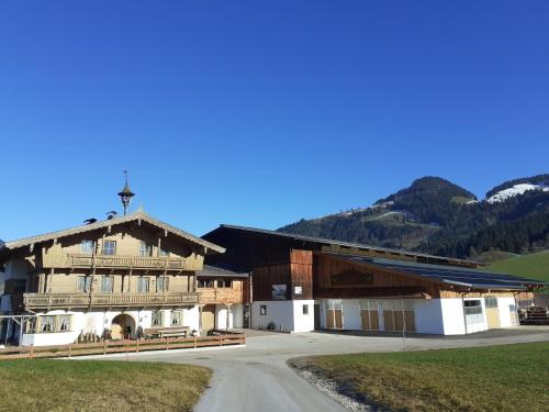 a large wooden building with mountains in the background at Maurerhof Itter in Itter