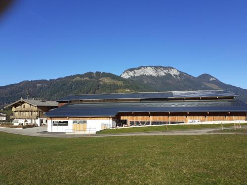 a large building with a mountain in the background at Maurerhof Itter in Itter