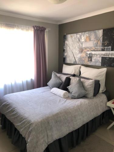 Un dormitorio con una cama grande con almohadas. en Summer Sands - Durban North Beach Accommodation, en Durban