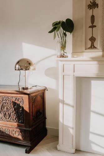 a table with a lamp on it next to a fireplace at Brass Hotel in Utrecht