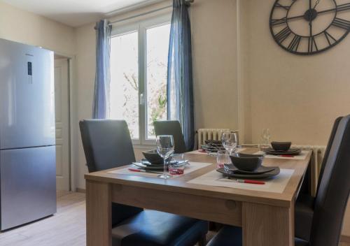 une table à manger avec des chaises et une horloge murale dans l'établissement SWEETHOME DIJON - Gare, à Dijon