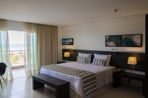 a bedroom with a bed with a view of the ocean at Crocobeach Hotel in Fortaleza