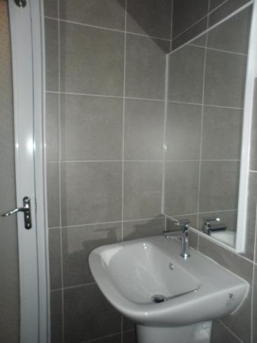 a bathroom with a white sink and a shower at Austin Homestay in Ipoh