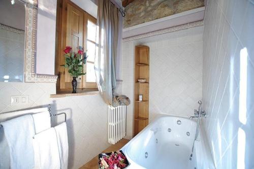 a bathroom with a bath tub and a window at Agriturismo Ardene in Montepulciano