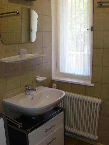 a bathroom with a sink and a window and radiator at Appartement Ingrid in Ellmau