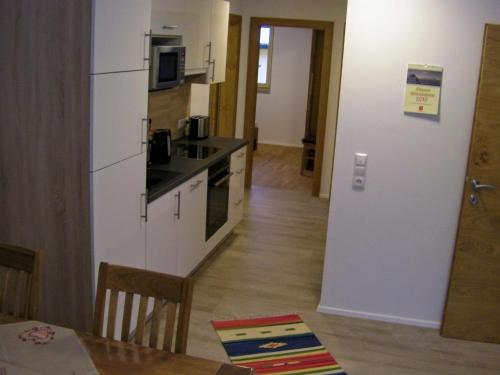 a kitchen with a white refrigerator and a table at Appartement Ingrid in Ellmau