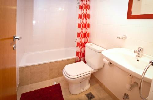 a bathroom with a toilet and a sink and a tub at Sabatico Suites in Buenos Aires
