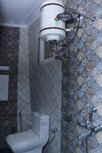 a bathroom with a toilet and a water tank at Solan Retreat in Solan