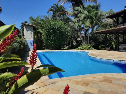 a swimming pool in a resort with palm trees at Casa Pomar do Aconchego in Paraty