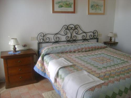 a bedroom with a bed and a wooden nightstand with a bed sidx sidx sidx at room in farmhouse near san gimignano in San Gimignano