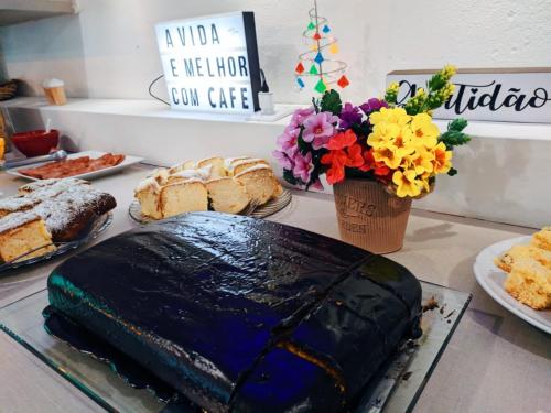 Pousada Graff في بنها: كعكة موضوعة على منضدة مع الخبز والزهور