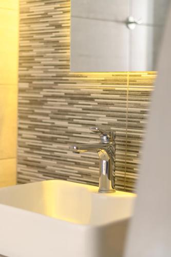 a bathroom with a sink and a mirror at Moonlight Apartments & Suites in Fira