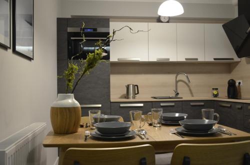 una cocina con una mesa con platos y vasos. en "11" SŁOŃCE WODA LAS - Apartament No11 Garaż w cenie, en Kielce
