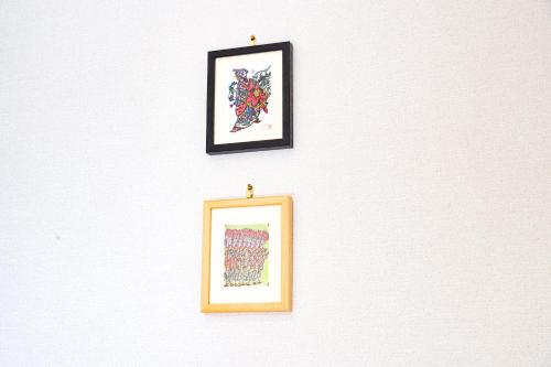 two framed pictures hanging on a white wall at Riverside Yofuke AFP Villa in Nago