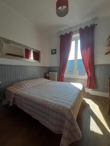 une chambre avec un lit et une fenêtre avec des rideaux rouges dans l'établissement Les 4 Montagnes, à Villard-de-Lans