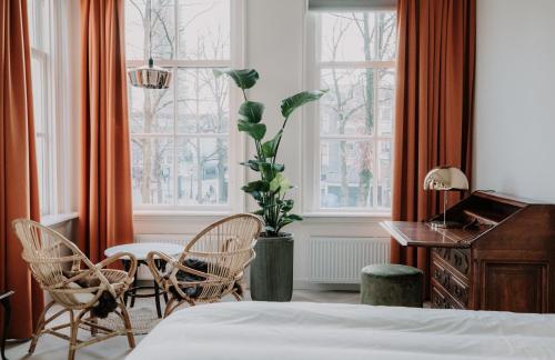 a bedroom with a bed and a table and chairs at Brass in Utrecht