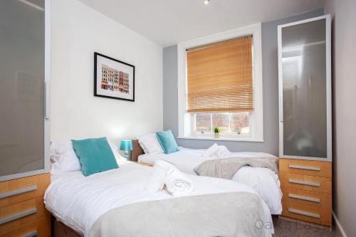 1 dormitorio con 2 camas y ventana en Oakstays City Centre Gem, en Newcastle