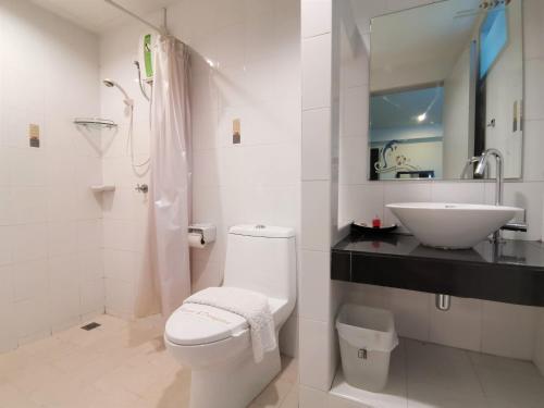 ein weißes Bad mit einem WC und einem Waschbecken in der Unterkunft Phupara Place SHA Certified in Phuket