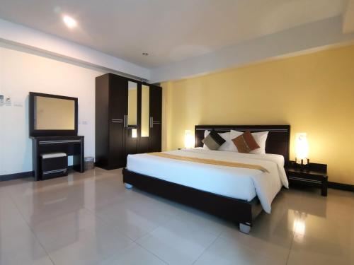 a bedroom with a large bed and a television at Phupara Place SHA Certified in Phuket Town