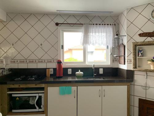 a kitchen with a sink and a window at Recanto da Sol in Florianópolis