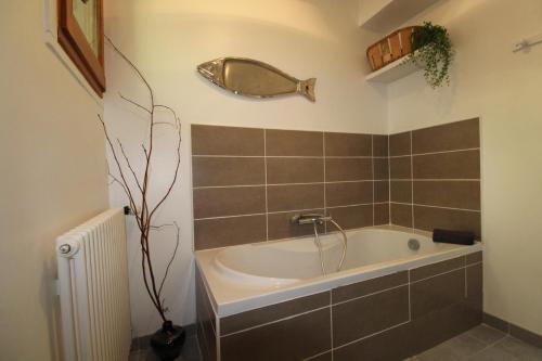 een badkamer met een bad en een spiegel aan de muur bij Le Chalet 07 in Saint-Agrève