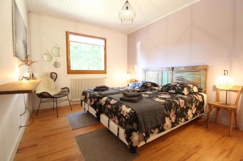 une chambre avec un lit, une chaise et une fenêtre dans l'établissement Le Chalet 07, à Saint-Agrève