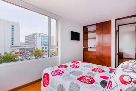 sypialnia z łóżkiem i dużym oknem w obiekcie Apartamento Amoblado Ciudad Salitre Bogotá w mieście Bogota