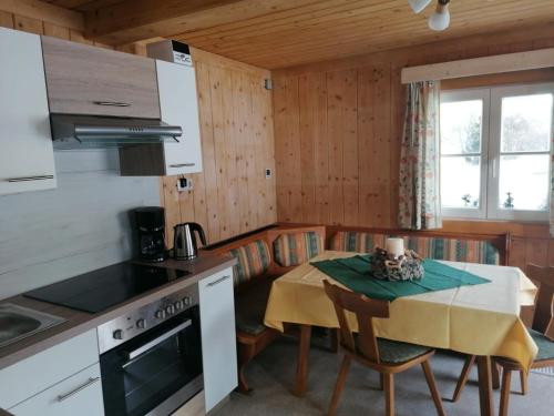 een keuken met een tafel en een eetkamer bij Berghütte Franz'l in Aich