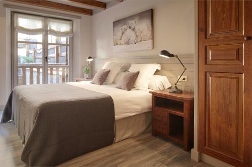 een slaapkamer met een bed en een lamp op een tafel bij Val de Ruda Luxe 9 by FeelFree Rentals in Baqueira-Beret