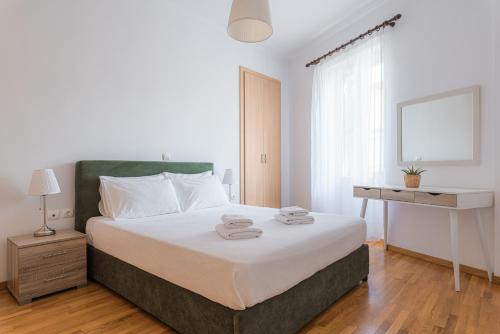 um quarto com uma cama e uma secretária com toalhas em Villa Porto- Naftilos Residences em Pythagoreio