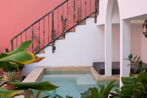 a house with a swimming pool under a staircase at BOHO Bohemian Boutique Hotel in Willemstad