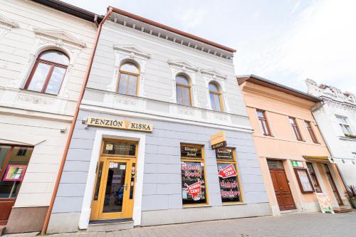 a white building on the corner of a street at Penzion Kiska Kežmarok in Kežmarok
