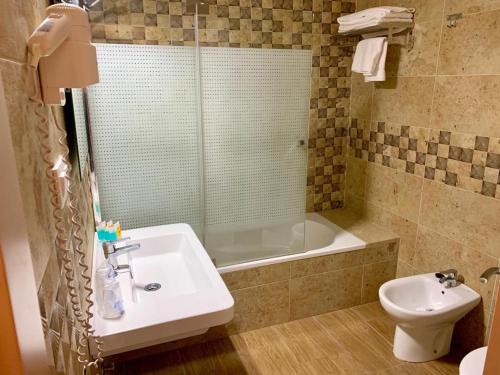 
a bathroom with a toilet, sink, and bathtub at Hotel Almadrabeta in Zahara de los Atunes
