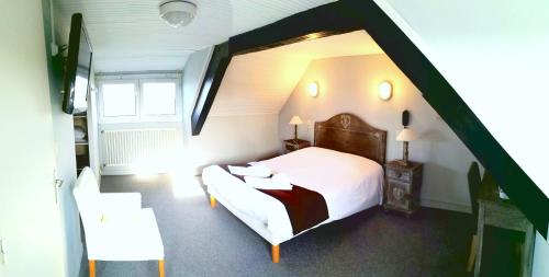 A bed or beds in a room at Logis Hôtel Le Bretagne