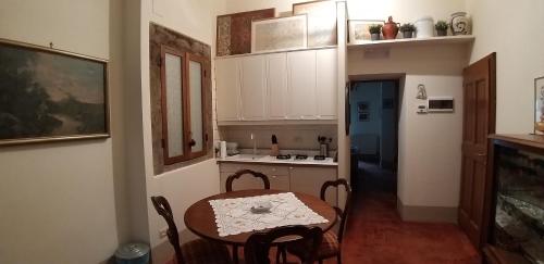 a small kitchen with a table and a table and chairs at Finestra Dell'Angelo in Pienza