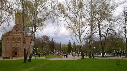 a park with trees and a building with a clock tower at Апартаменты в центре (Красная площадь) in Chernihiv