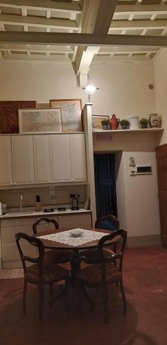 a kitchen with a table and two chairs and a stove at Finestra Dell'Angelo in Pienza