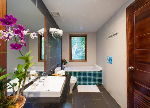 a bathroom with a tub and a toilet and a sink at Nadine Phu Quoc Resort & Spa in Phú Quốc