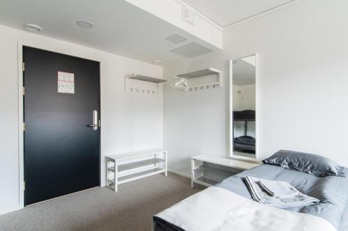 a room with two beds and a mirror in it at Aikatalo Hostel Helsinki in Helsinki