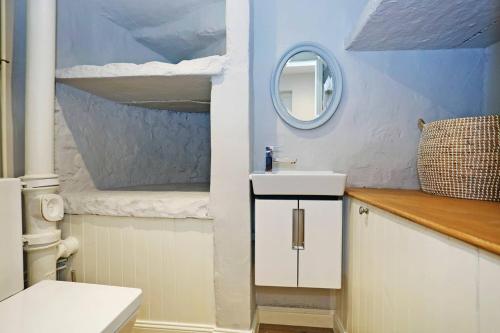 a bathroom with a sink and a mirror at ALTIDO Vibrant 2 Bedroom Apartment in City Centre in Edinburgh