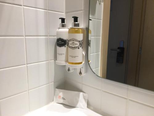 a bathroom sink with two shampoo bottles on a mirror at Hotel Convento do Salvador in Lisbon