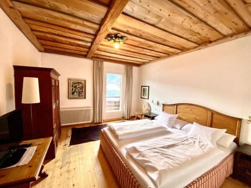 a bedroom with a large bed and a wooden ceiling at Appartements Greier in Telfes im Stubai