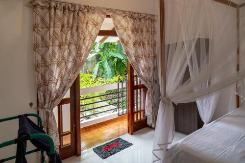 a bedroom with a bed and a window with a balcony at Happy Villa in Hikkaduwa