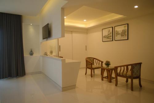 a living room with two chairs and a kitchen at Boon Inn in Malappuram