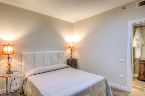 a small bedroom with a bed and two lamps at Right House di Via Sulis - Best Neighborhood in the Town in Cagliari