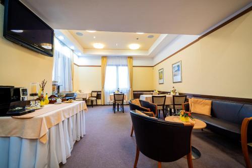 a living room with tables and a couch and a dining room at Penzion Kiska Kežmarok in Kežmarok