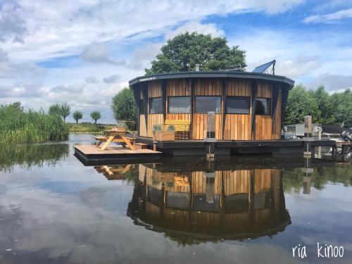 a tiny house on a dock in the water at Dobberhuisje in Nieuwkoop