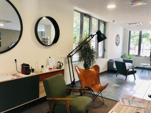 a waiting room with chairs and a mirror at All Suites Appart Hôtel - Bordeaux Centre Gare in Bordeaux