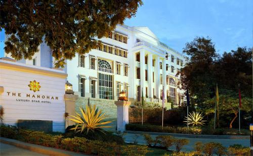 a white building with a sign in front of it at The Manohar Hyderabad in Hyderabad