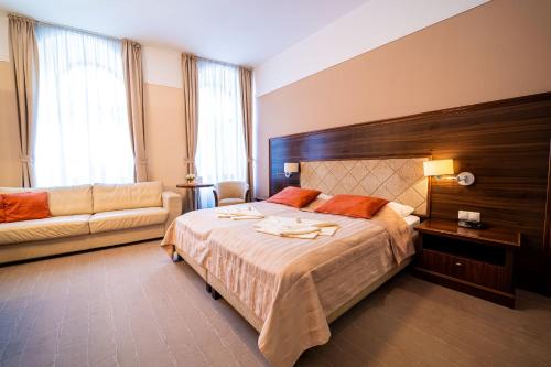 a bedroom with a large bed and a couch at Penzion Kiska Kežmarok in Kežmarok